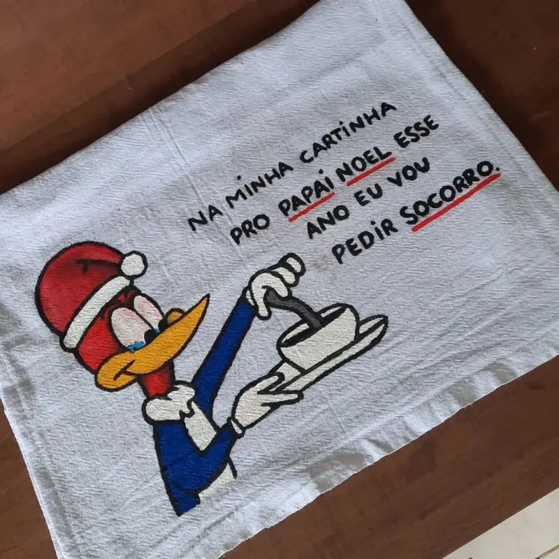 imagem de pano de prato com desenho do pica-pau e a frase: na minha cartinha pro papai noel esse ano eu vou pedir socorro.