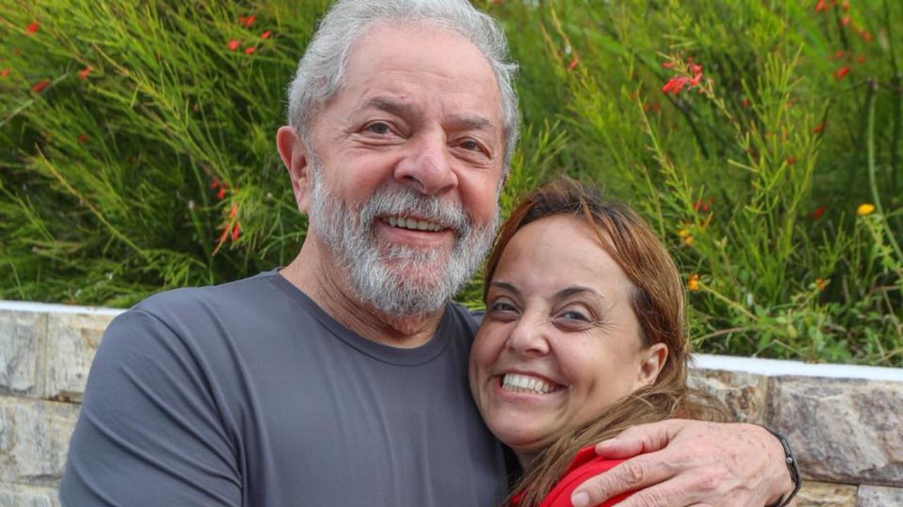 Lula sorrindo ao lado da filha Lurian em um ambiente ao ar livre.