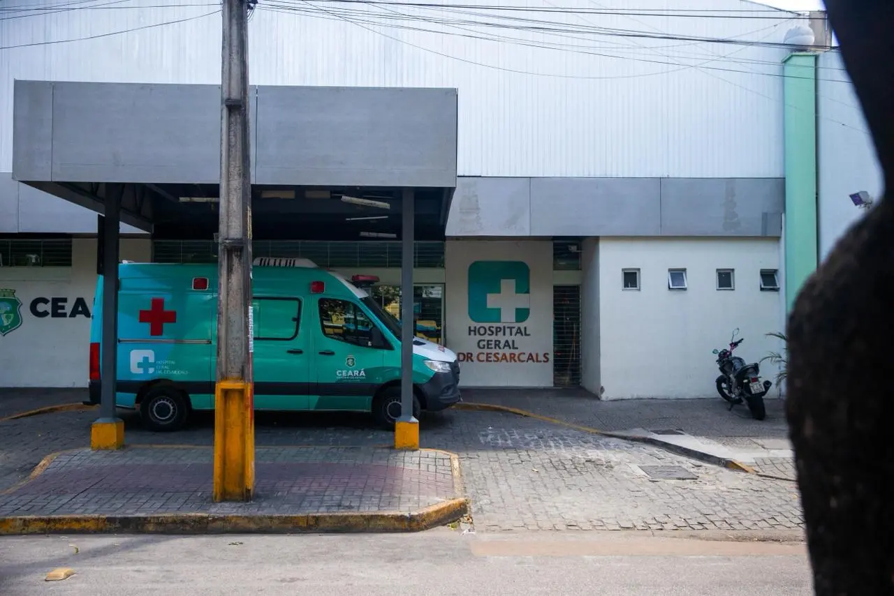 Imagem mostra fachada do Hospital Geral Dr. César Cals, em Fortaleza, com uma ambulância estacionada na porta.