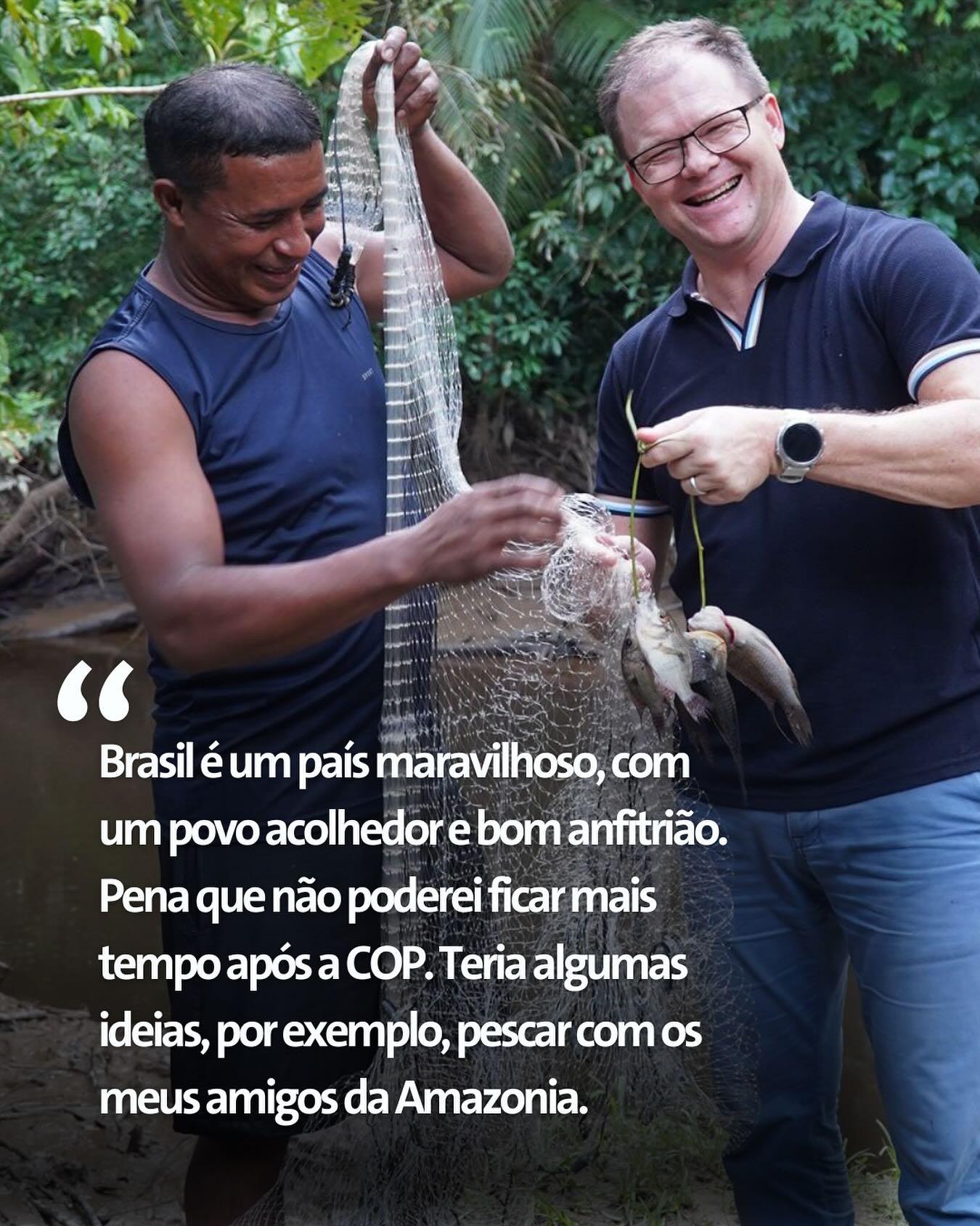 Imagem mostra pescador local da Amazônia e o ministro do Meio Ambiente da Alemanha, Carsten Schneider, com um mostrando a rede e o outro os peixes, destacando a conexão cultural e a natureza.