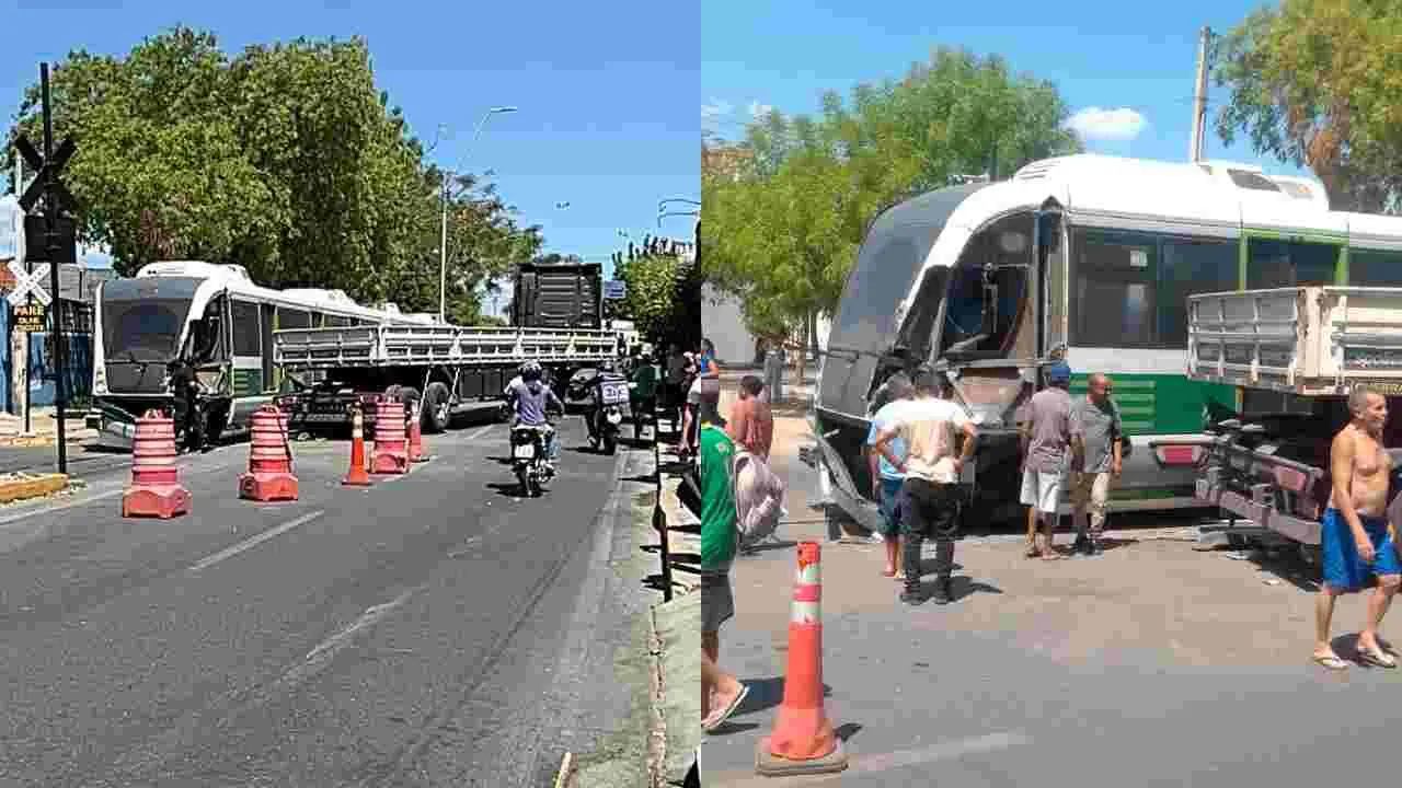 ALT: Uma montagem de duas fotos mostrando um acidente entre um Veículo Leve sobre Trilhos (VLT) e um caminhão em uma área urbana. A foto da esquerda mostra a visão geral do local: o VLT de cor branca e verde está parado ao lado de um caminhão prancha de carroceria escura, que está posicionado de forma transversal ou parcialmente sobre os trilhos. Cones de trânsito laranja e brancos estão na via, bloqueando o trânsito. A foto da direita é um close-up que mostra a frente do VLT encostada na lateral da carroceria do caminhão. Várias pessoas, incluindo curiosos e talvez trabalhadores, estão aglomeradas ao redor dos veículos acidentados. O céu está claro e o dia é ensolarado.