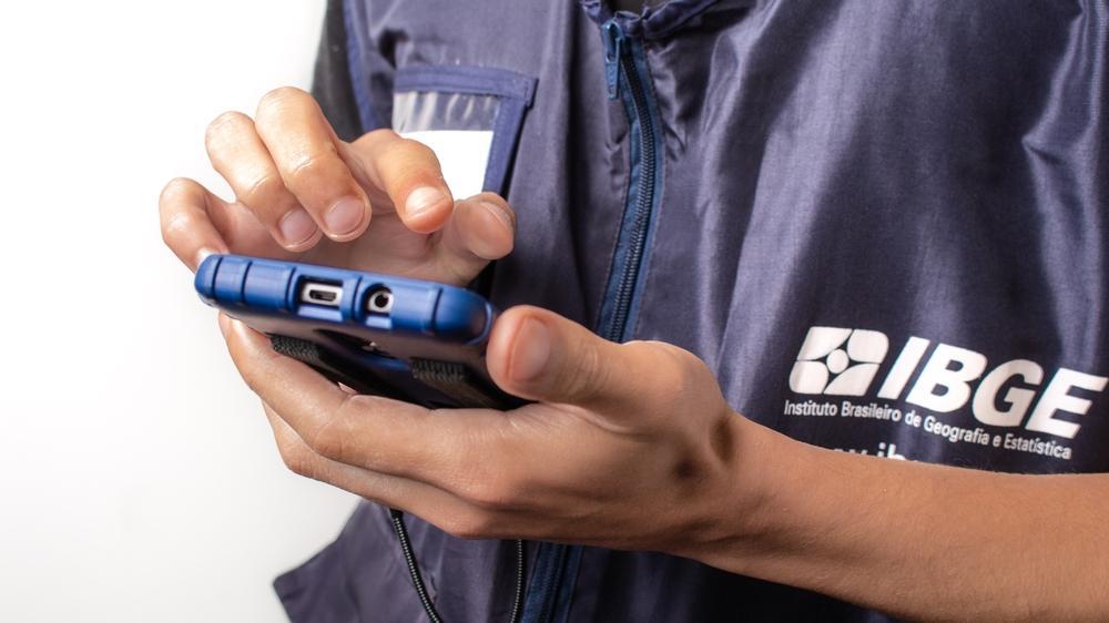 foto de agente do IBGE manuseando equipamento.