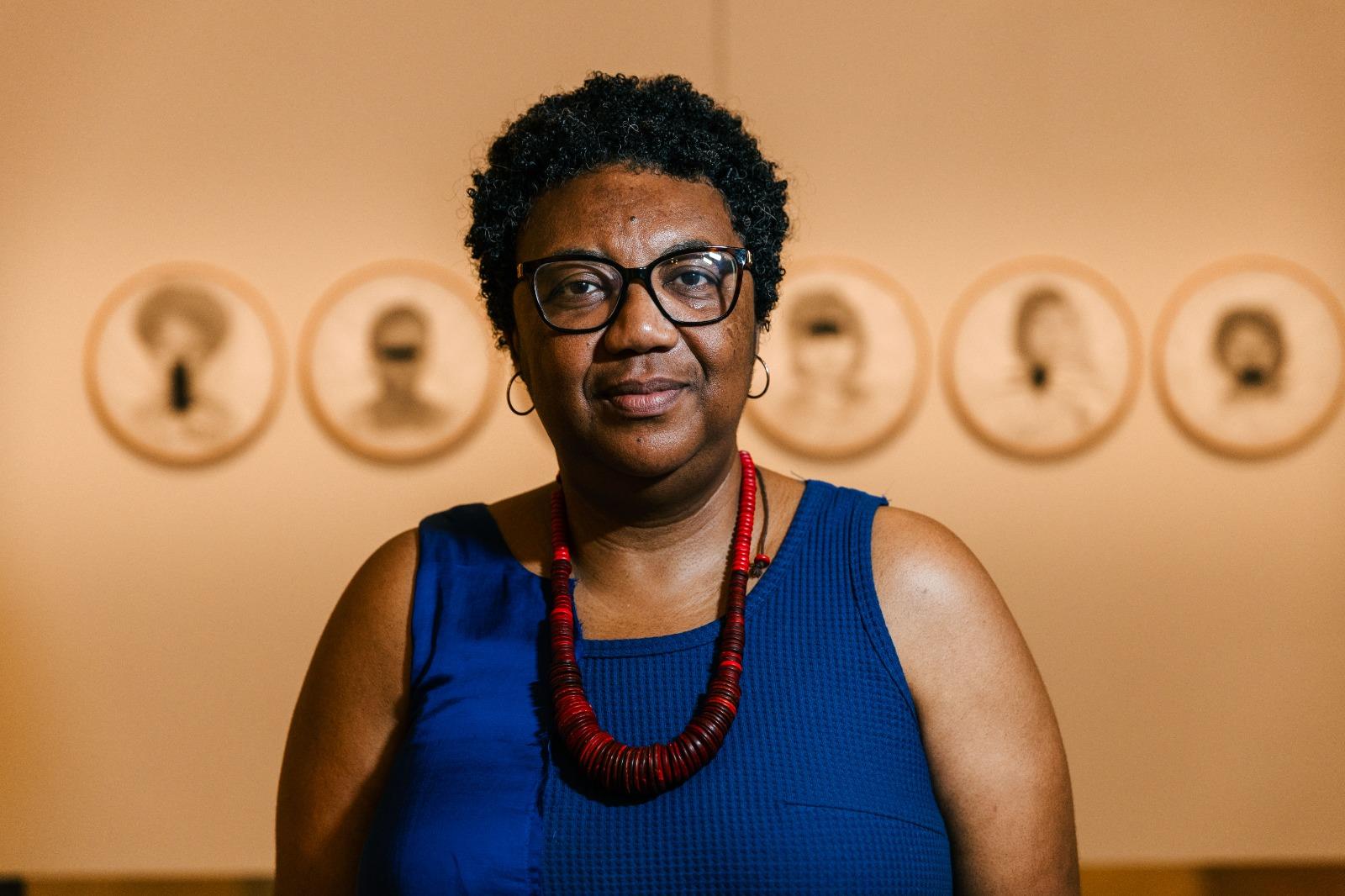 Artista posa em frente da obra 'Bastidores', atualmente em exposição na Pinacoteca do Ceará.