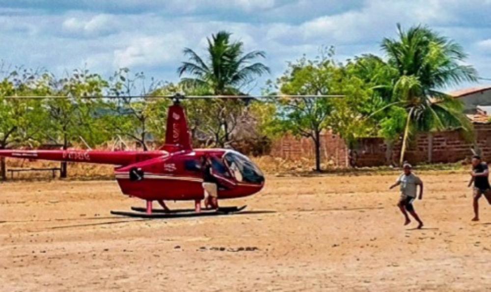 A imagem mostra dois homens correndo, próximo a um helicóptero, onde há uma pessoa, em uma cena de assalto.