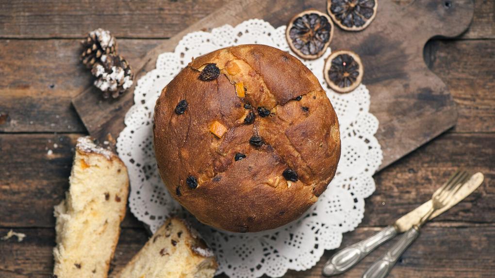 Foto de panetone com frutas cristalizadas com uma fatia cortada.