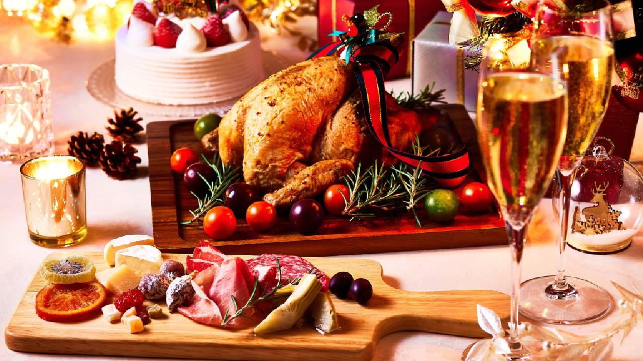 Mesa festiva de Natal com um peru assado, decorado com alecrim e tomates.