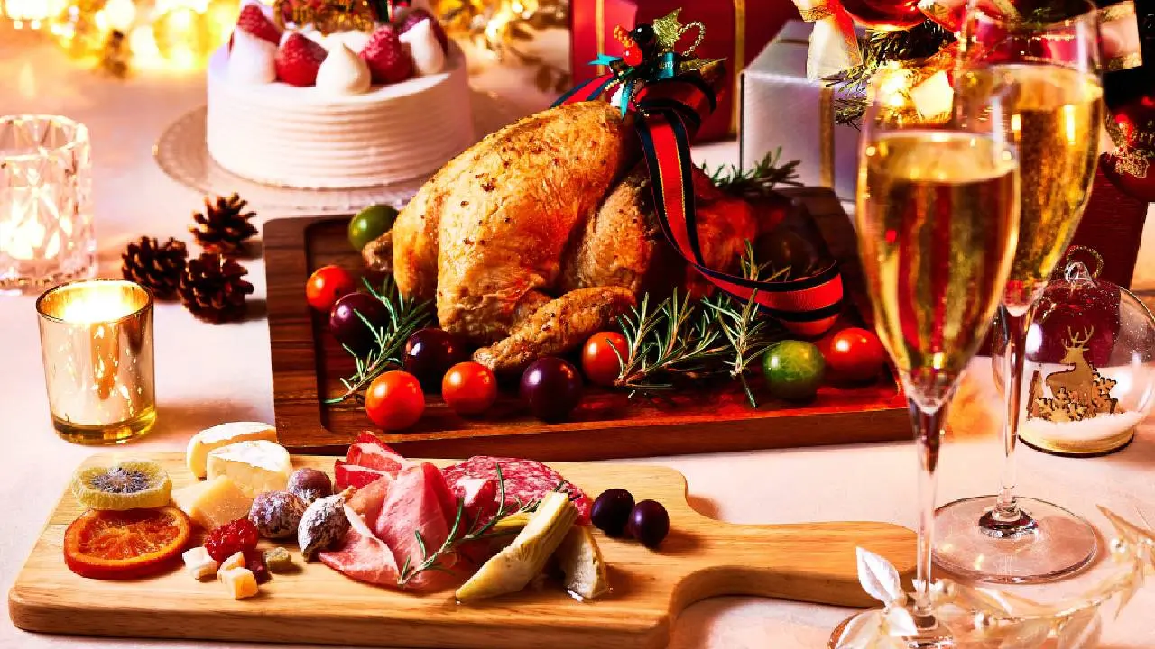 Mesa festiva de Natal com um peru assado, decorado com alecrim e tomates.