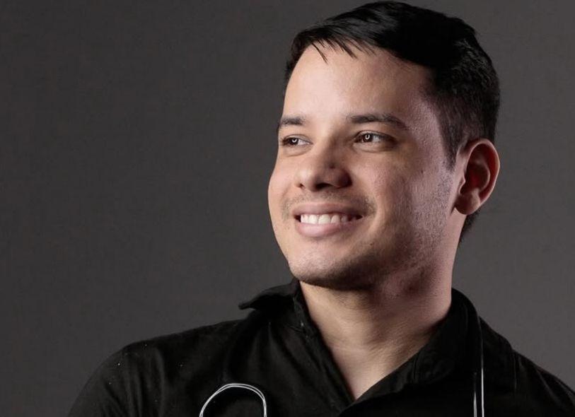 Edcley Teixeira de perfil. É um homem jovem, de cabelo preto. Na foto, usa camisa de botão preta e está com um estetoscópio sobre o pescoço.