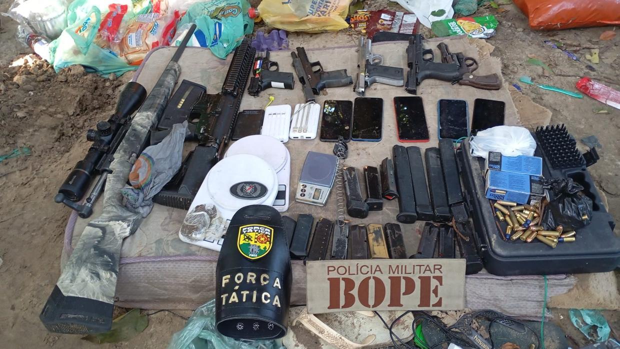 A foto mostra diversas armas de fogo e celulares apreendidos com suspeitos mortos em uma ação policial em Caucaia.