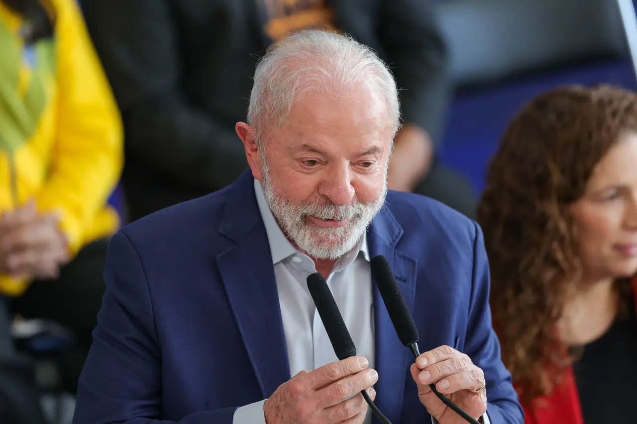 Lula discursando em cerimônia no Palácio do Planalto vestindo paletó azul.