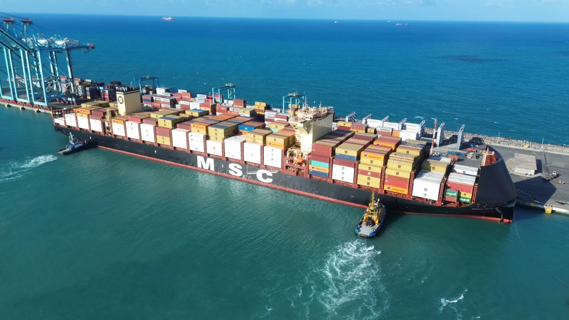 Vista aérea de um berço do Porto do Pecém com navio cheio de contêineres.