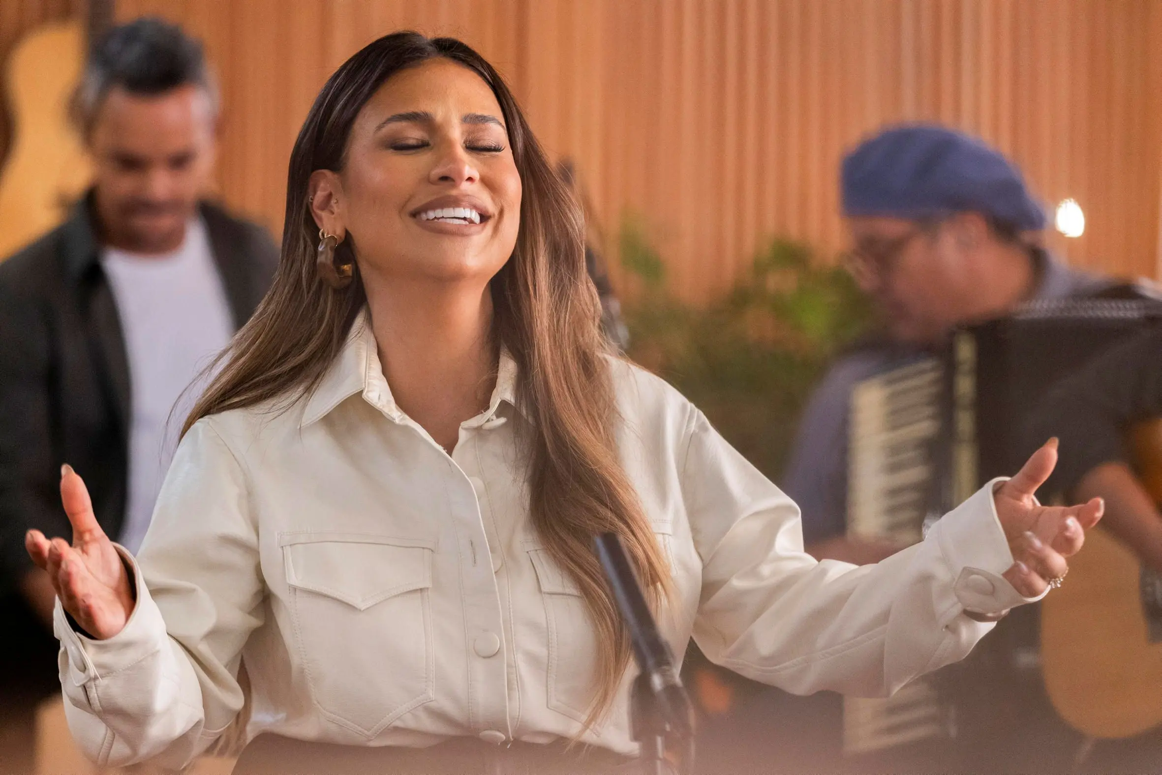 Simone Mendes cantando. ela está com olhos fechados e braços abertos.