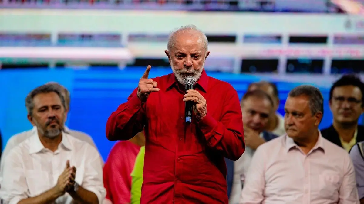 Lula veste roupa vermeha e fala ao microfone