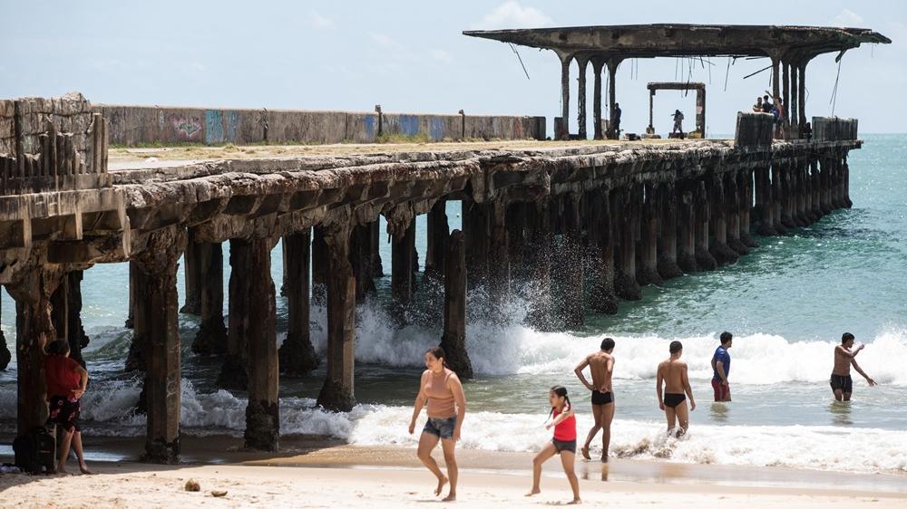 Foto da orla de Fortaleza com banhistas.