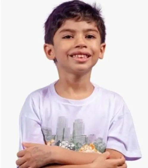 O menino Benício tinha 6 anos. Era magro e tinha o cabelo preto. Na foto, usa uma camiseta branca e está sorrindo, de braços cruzados. Imagem usada em matéria sobre prints em que a médica admite prescrição errada de adrenalina.