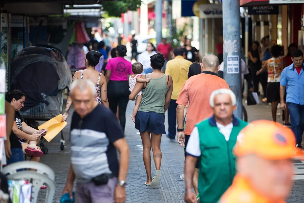 Multidão trabalhando em área central de cidade.