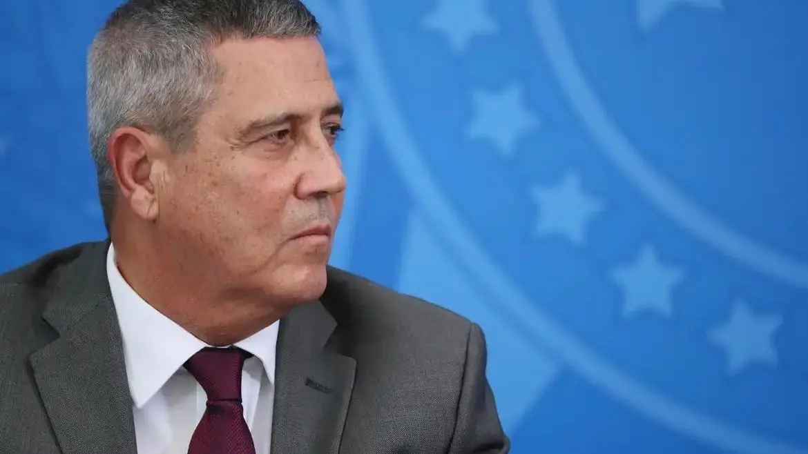 Braga Netto de perfil. É um homem de meia idade com cabelo curto grisalho. Na foto, ele está de terno cinza, camisa social branca e gravata vermelha.