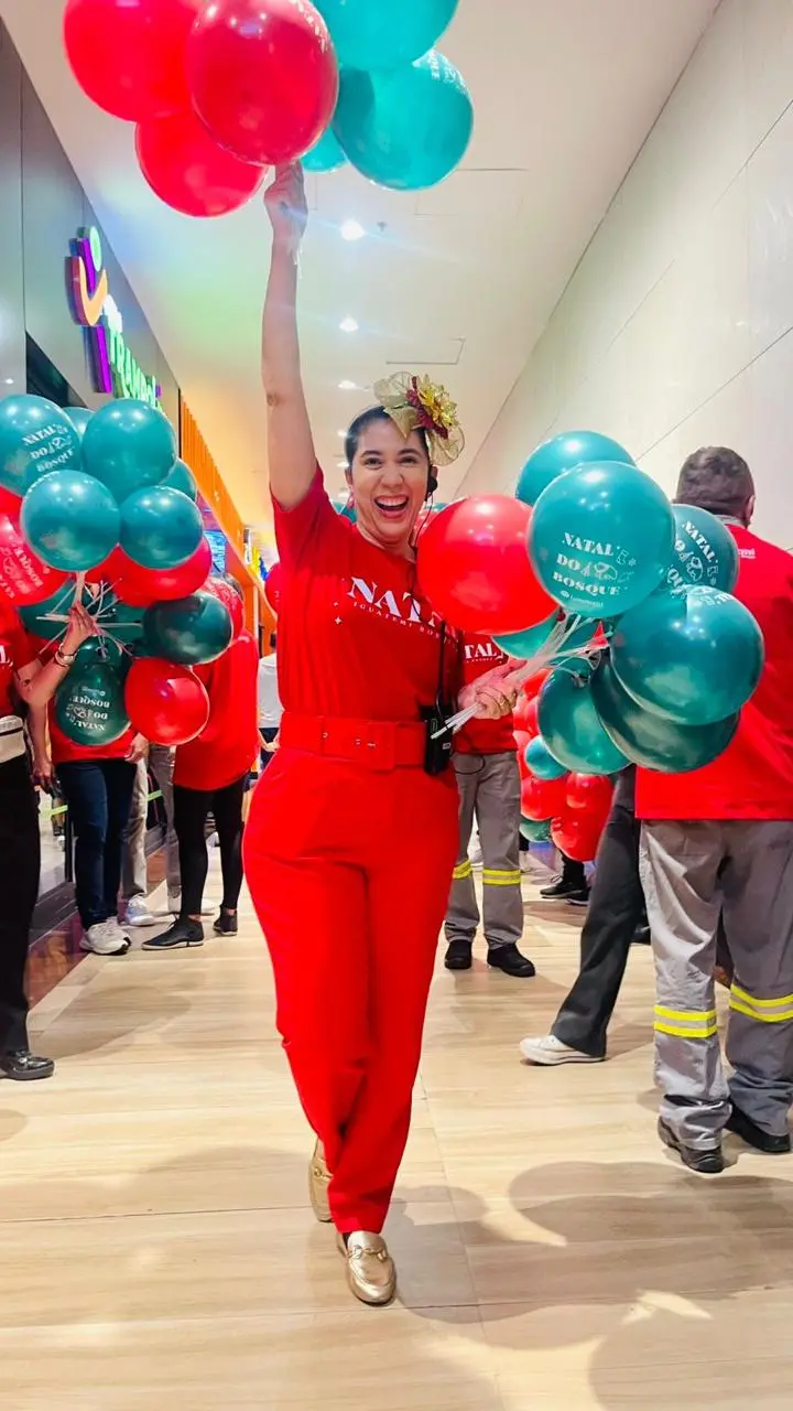 Mulher de roupa vermelha segura balões vermelhos e azuis de forma animada