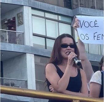 Juliette com microfone na mão em ato de protesto.