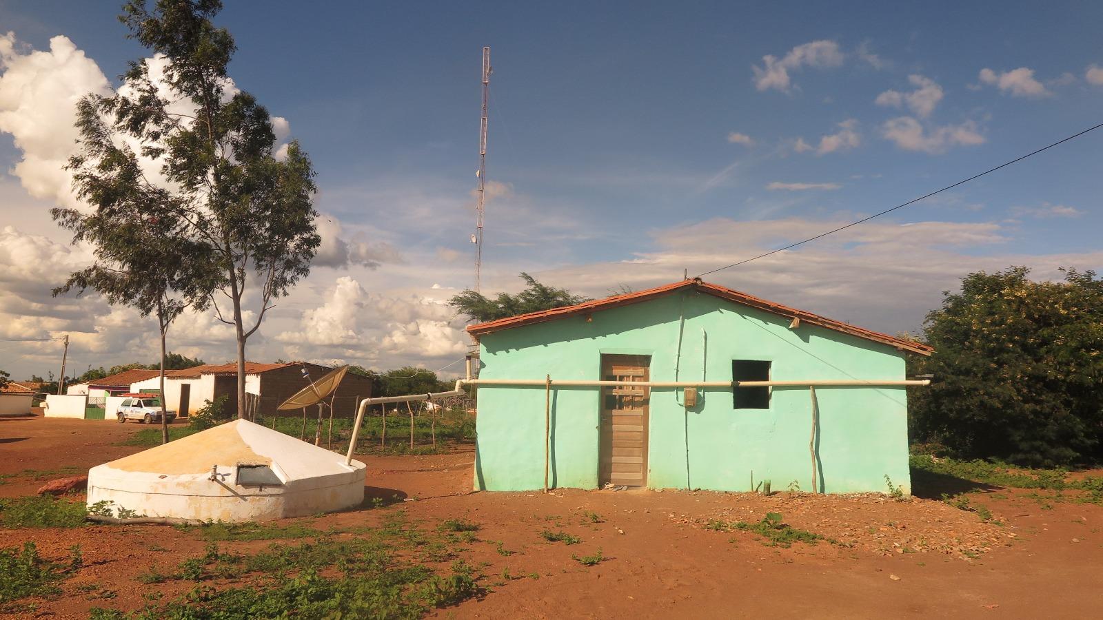 imagem mostra casinhas com cisterna no interior do Ceará. Ao fundo, tem uma antena para conexão com a internet.