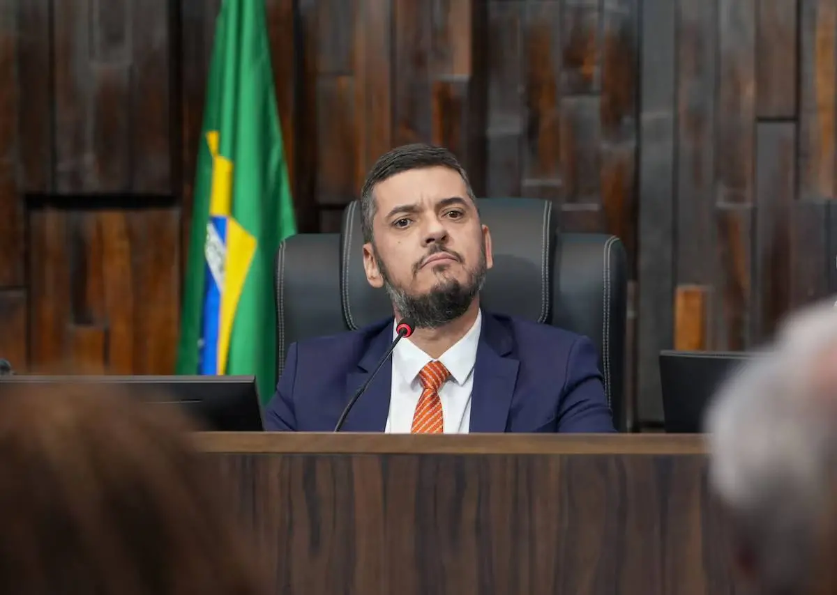 Imagem mostra Rodrigo Bacellar. Ele é um homem de meia idade e barba espessa. Na foto, ele está sorrindo e usa terno preto com camisa social branca e gravata lilás.