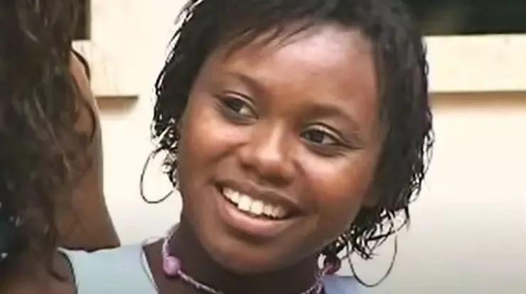 Aline é uma mulher jovem, negra, de cabelo curto. Na foto, ela está sorrindo de lado.