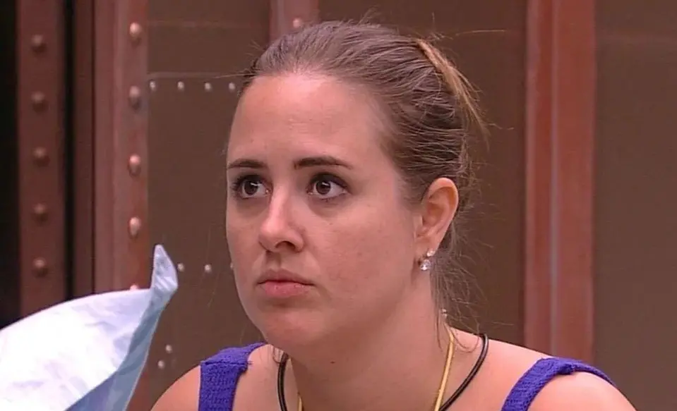 Patrícia é uma mulher branca e loira. Na foto, ela está de cabelo amarrado em um coque.