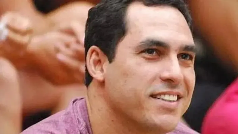 Felipe é um homem branco e de cabelo preto. Na foto, ele está sorrindo de lado.