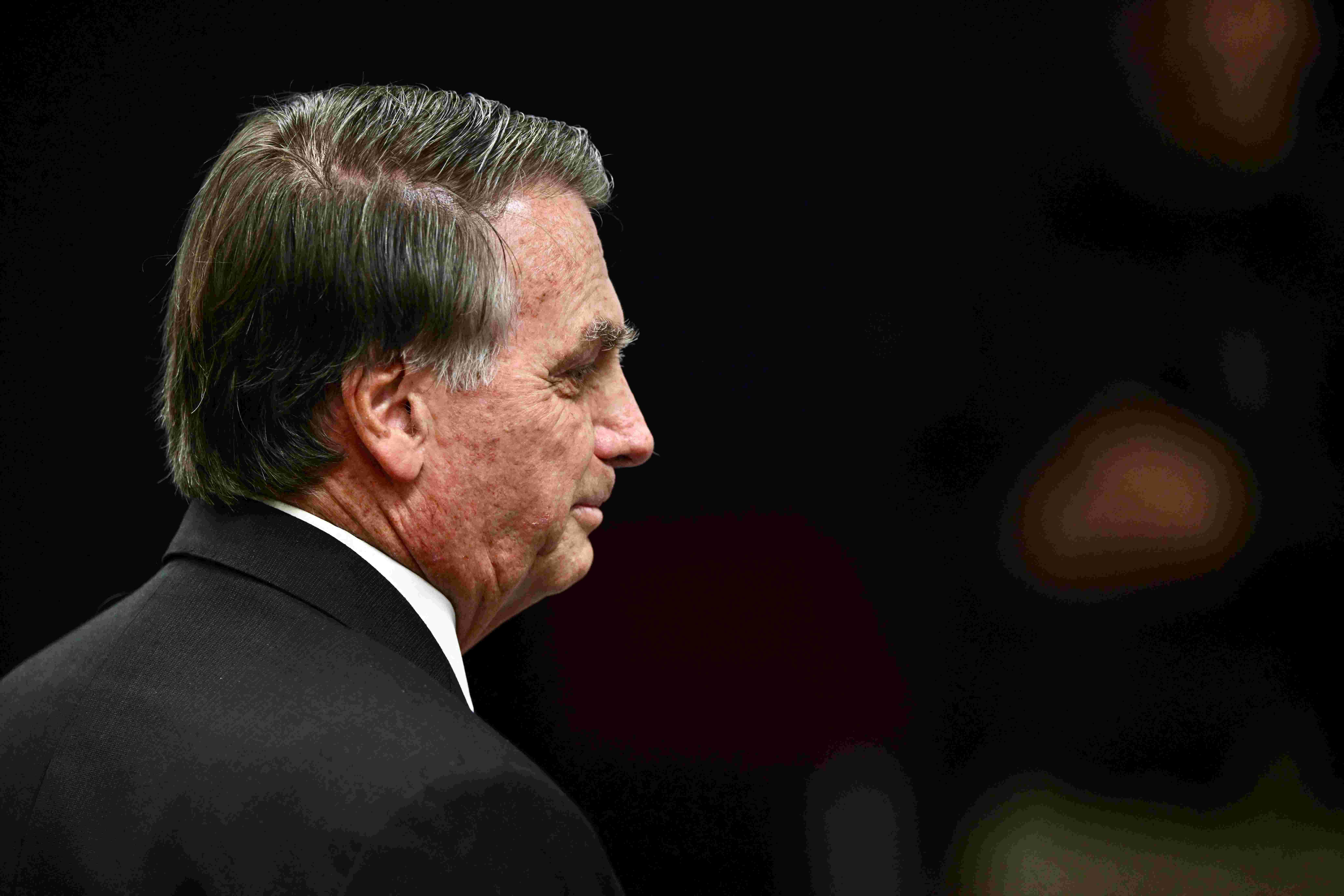 Imagem mostra ex-presidente Jair Bolsonaro em foto de close-up lateral, com expressão pensativa.