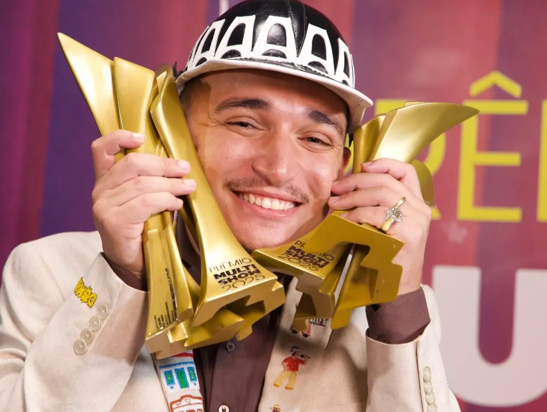 foto do cantor João Gomes segurando quatro prêmios Multishow na mão.