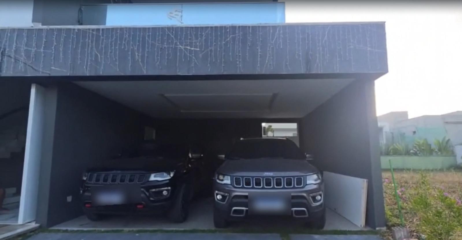 A foto mostra dois veículos Jeep Compass, de cores preta e prata, estacionados em uma casa de luxo, no Eusébio, onde foi realizada operação policial.