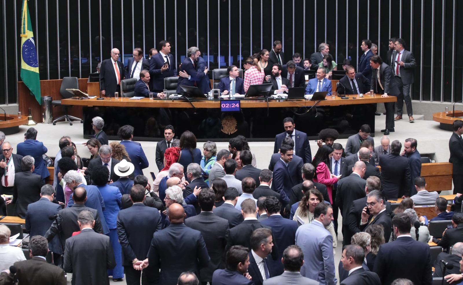 Foto do Plenário da Câmara dos Deputados com parlamentares tumultuados.