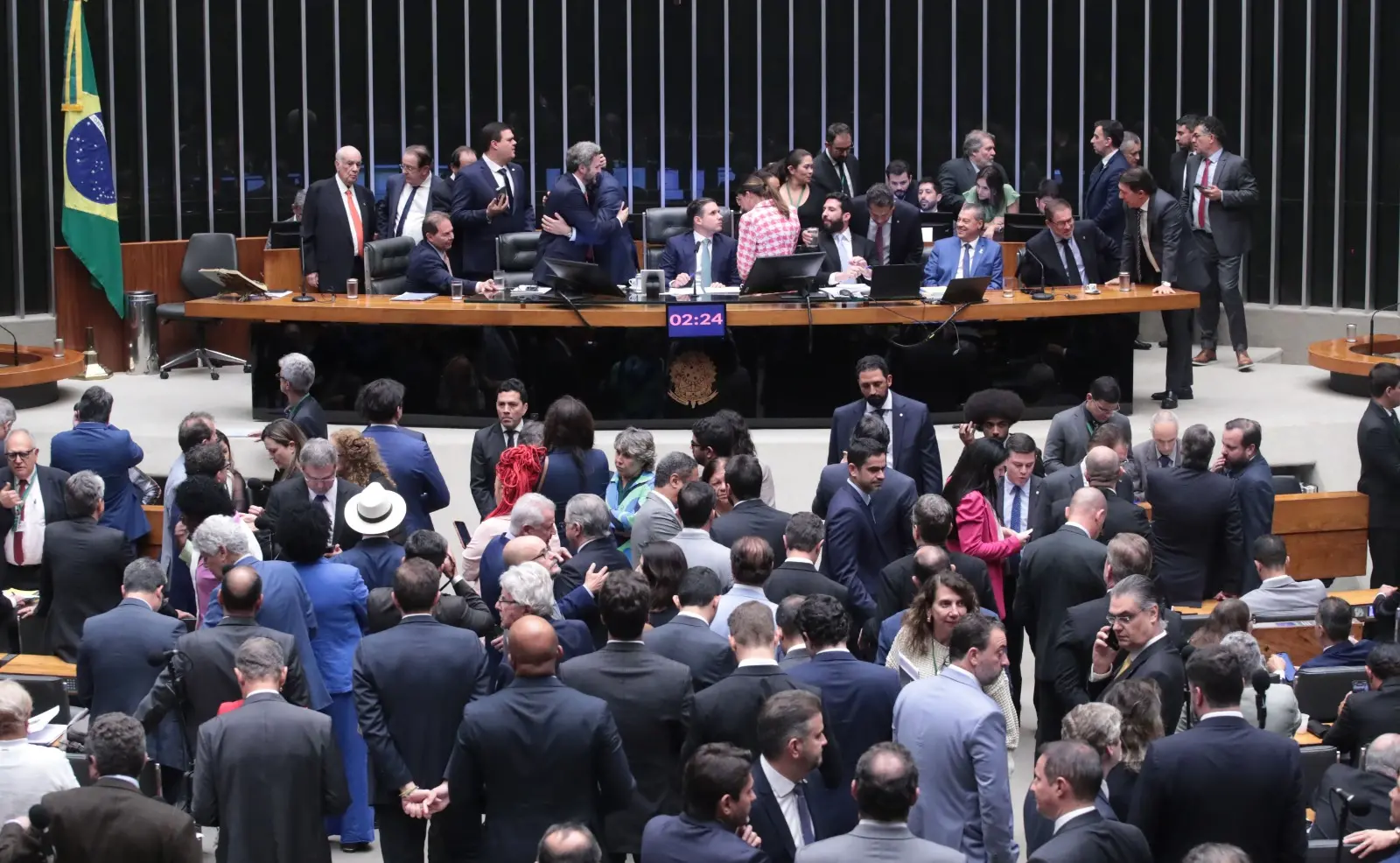 Foto do Plenário da Câmara dos Deputados com parlamentares tumultuados.