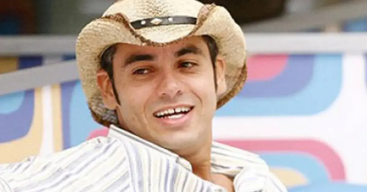 André é um homem branco de cabelo preto. Na foto, ele usa chapéu de cowboy.