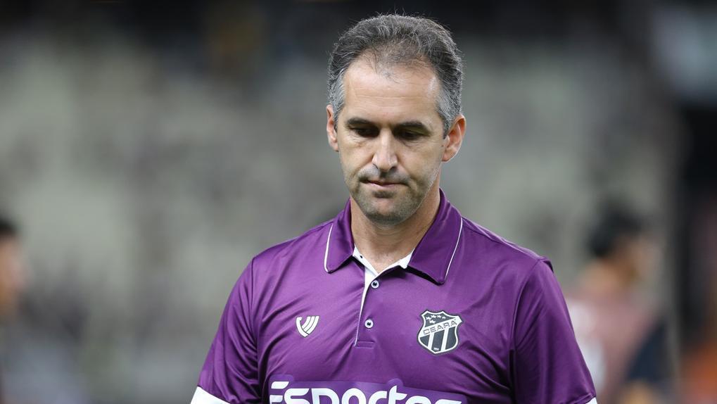 Na imagem Léo Condé usa blusa roxa e estar olhando para baixo. Foto usada em matéria onde informa que técnico não fará parte do Ceará em 2026.