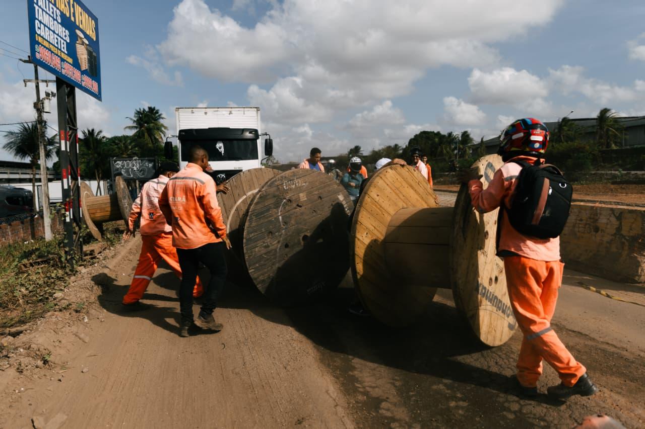Foto que contém trabalhadores do Consórcio Novo Anel Viário em protesto tampando a via com um carretel.