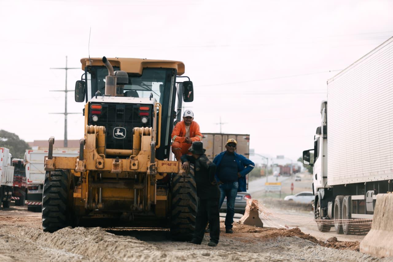 Foto que contém trabalhadores em cima de um trator no 4º Anel Viário.