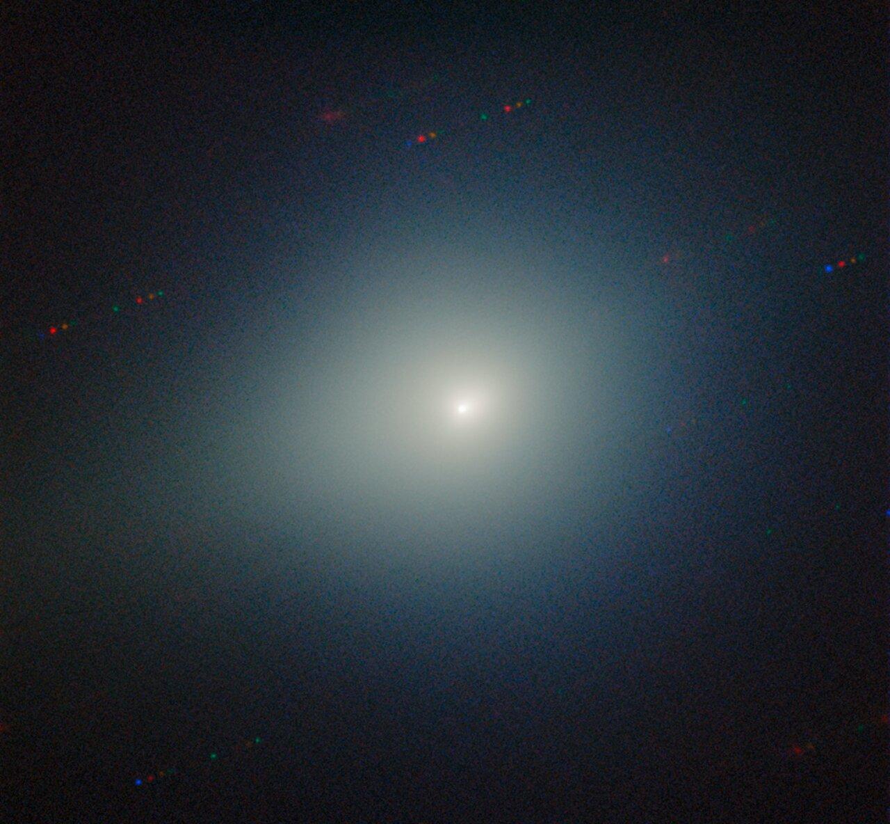 Imagem mostra o cometa interestelar 3I/ATLAS no centro, com um núcleo brilhante envolto por uma nuvem difusa de tonalidade esverdeada.