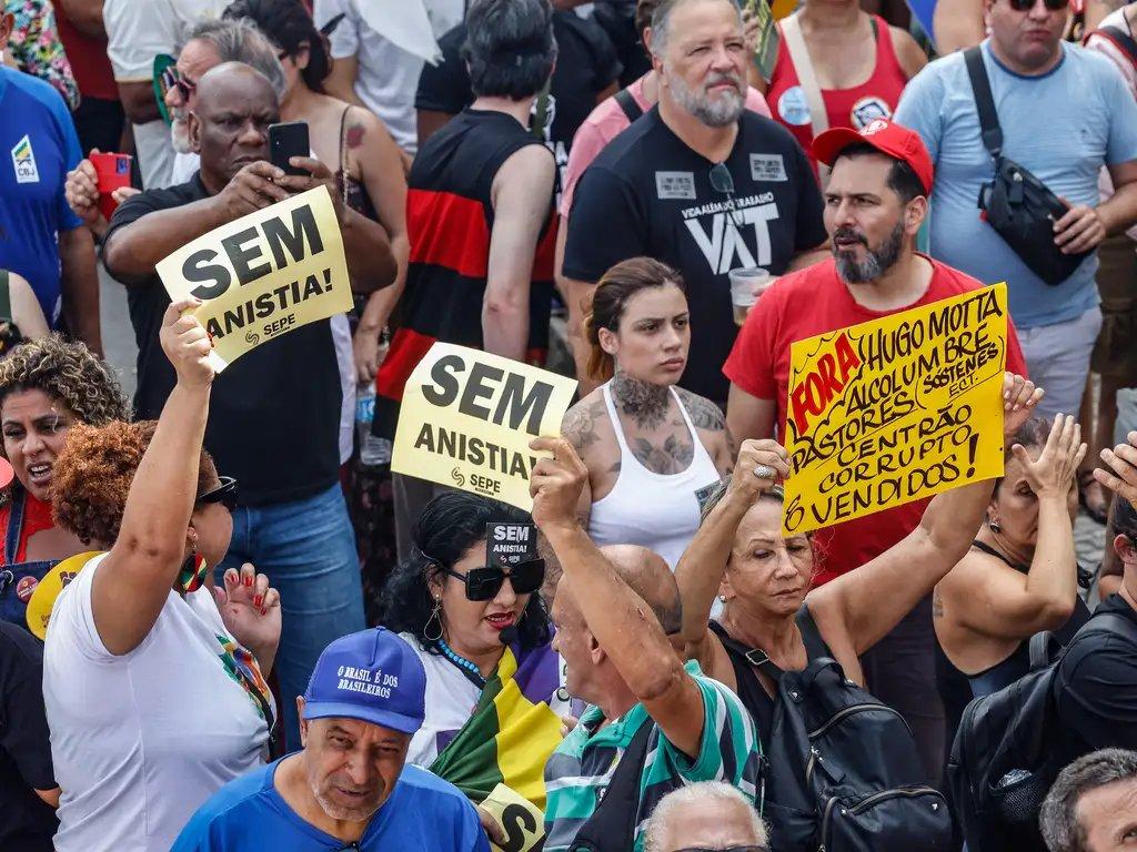 Pessoas seguram cartazes com dizeres 