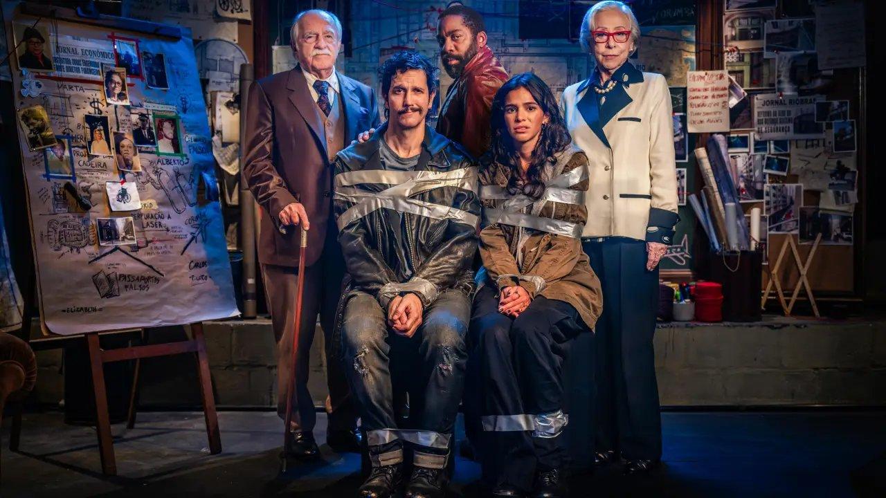 A imagem de divulgação do filme 'Velhos Bandidos' tem cinco pessoas, sendo três em pé e duas sentadas e amarradas, em um cenário que remete a investigação policial.