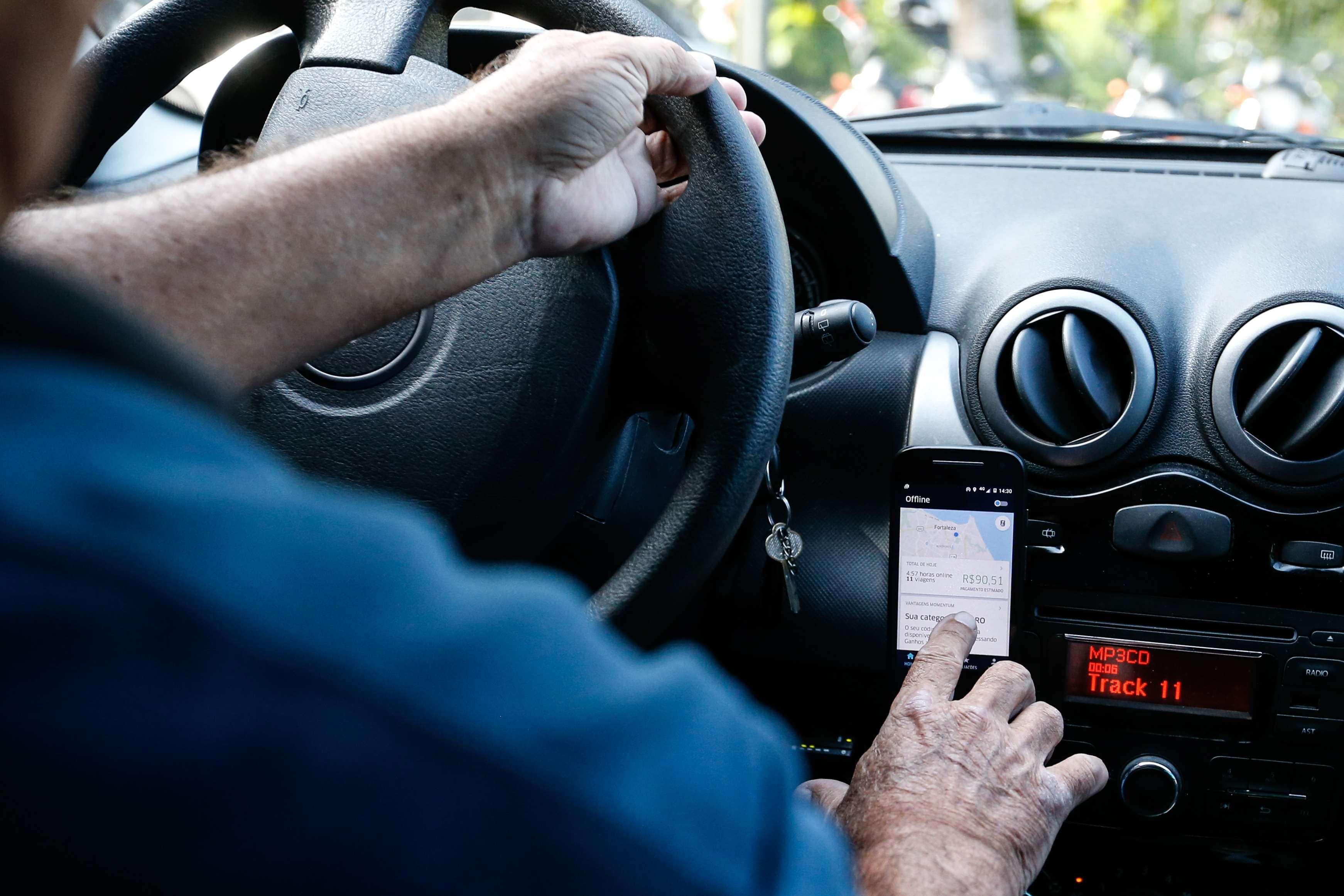 Foto de motorista de aplicativo no volante.