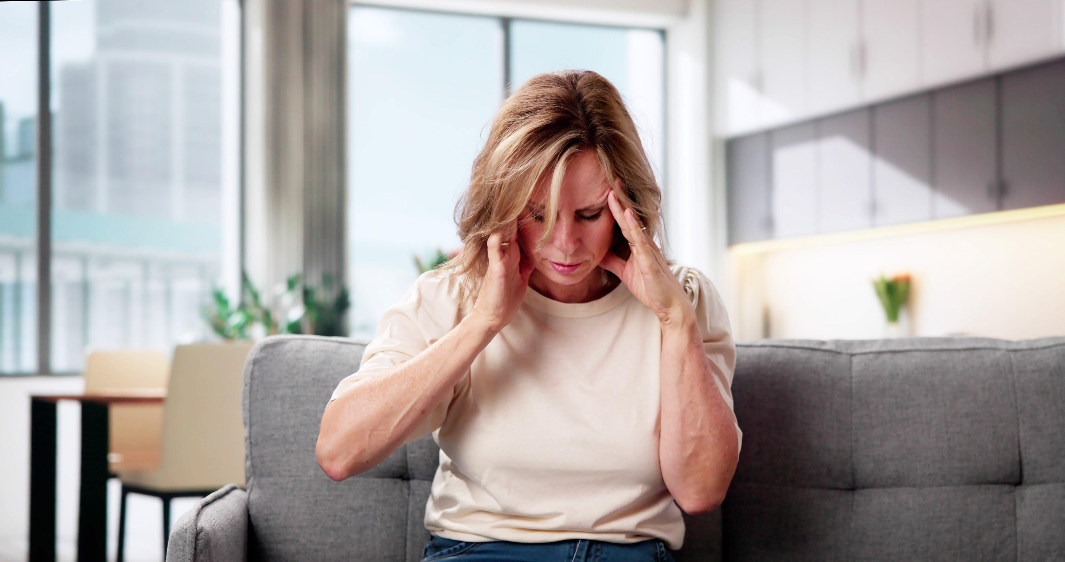 Imagem de uma mulher apresentando dor de cabeça para matéria sobre AVC em mulheres.
