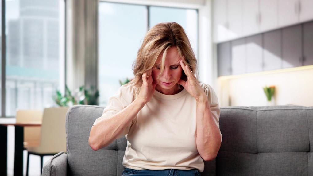 Imagem de uma mulher apresentando dor de cabeça para matéria sobre AVC em mulheres.