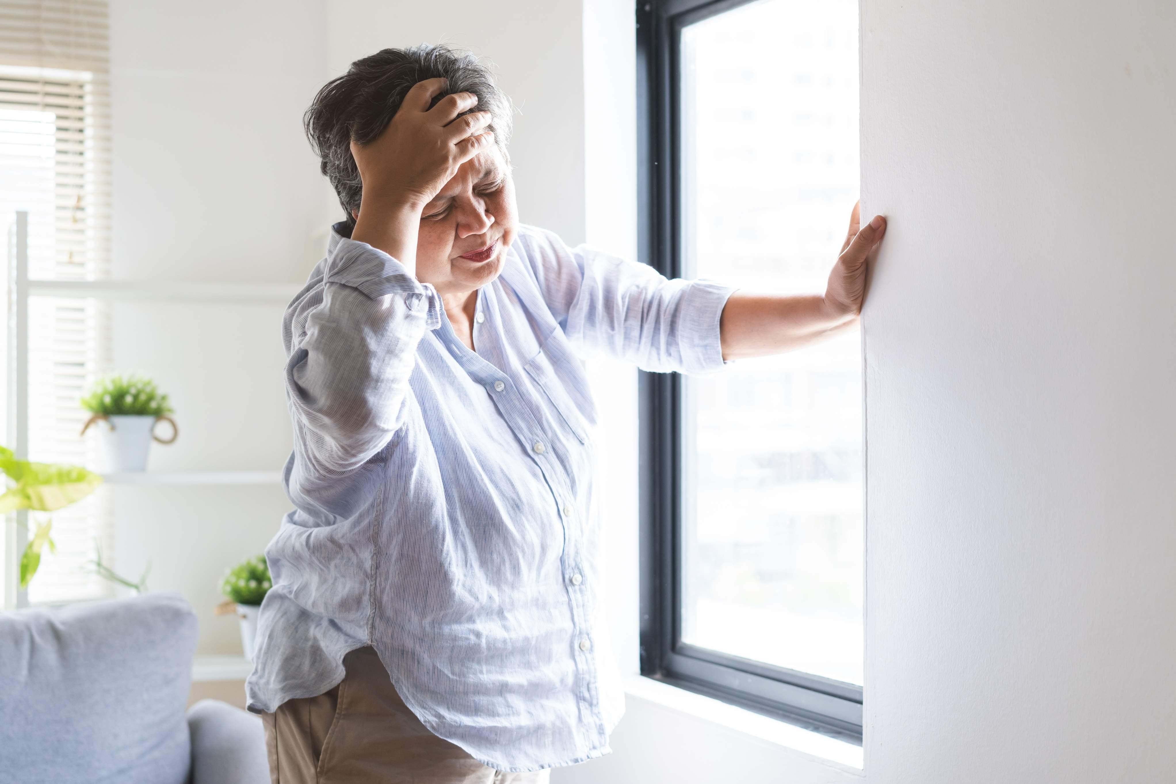 Imagem de uma mulher sentindo dores de cabeça para matéria sobre AVC.