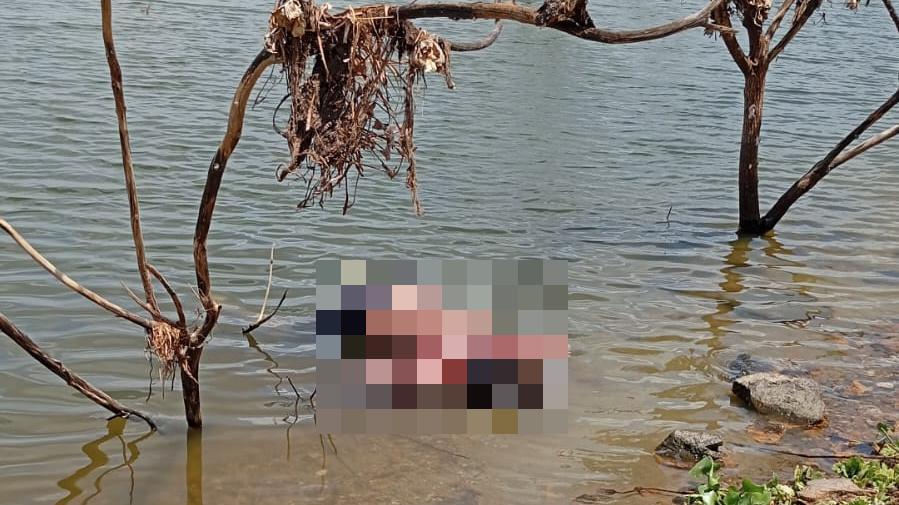 A imagem mostra a água de um açude, onde foi encontrado um corpo de uma pessoa, borrado na imagem.