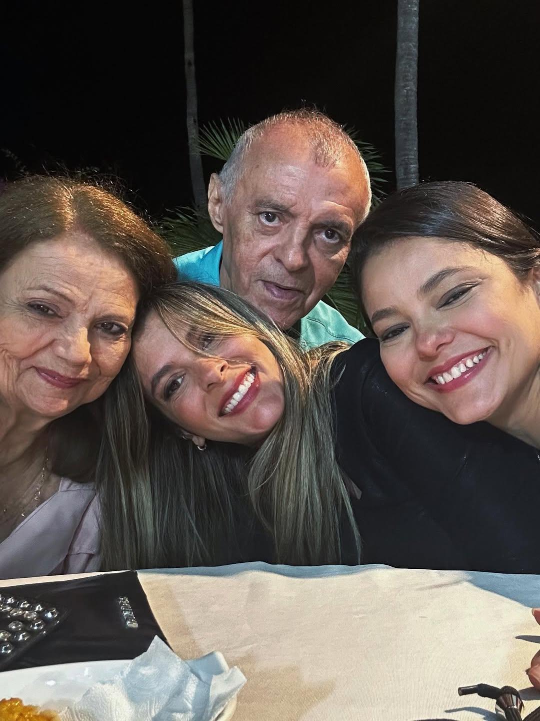 Foto estilo selfie que mostra uma mulher mais velha à esquerda e duas mulheres mais novas ao lado dela; acima, um senhor.