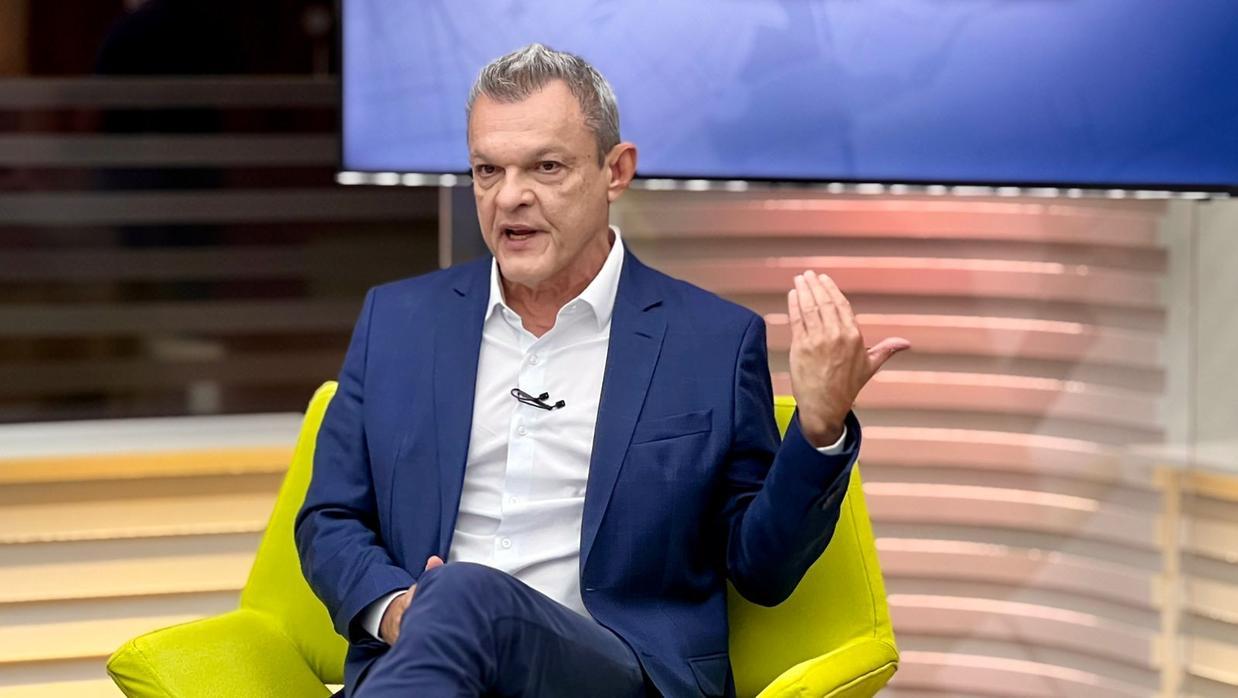 José Sarto, de blazer azul, concede entrevista e gesticula. Ele está sentado em um estúdio de TC.