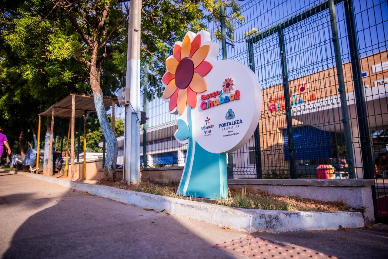 Totem do Espaço Girassol em frente à unidade, em área arborizada.