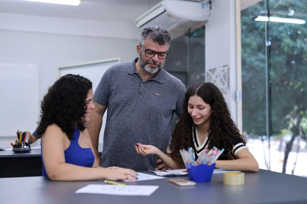 Professor orienta duas alunas em curso de férias Unifor.