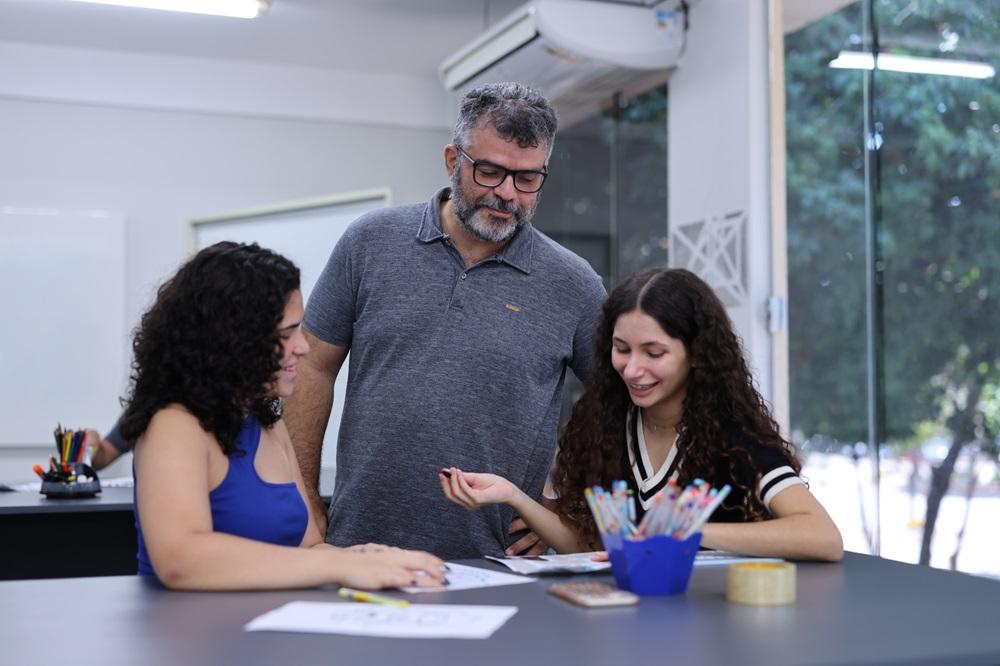 Professor orienta duas alunas em curso de férias Unifor.